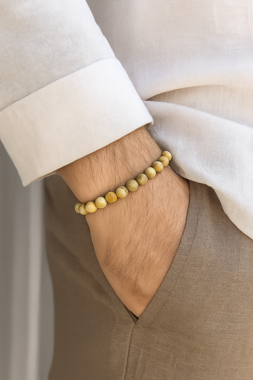 Cosmic Collections Jupiter herenarmband – handgemaakte elastische beige natuursteen kralenarmband gedragen bij linnen overhemd en taupe pantalon